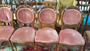 A set of six Victorian style walnut framed balloon back dining chairs with carved crest rails and