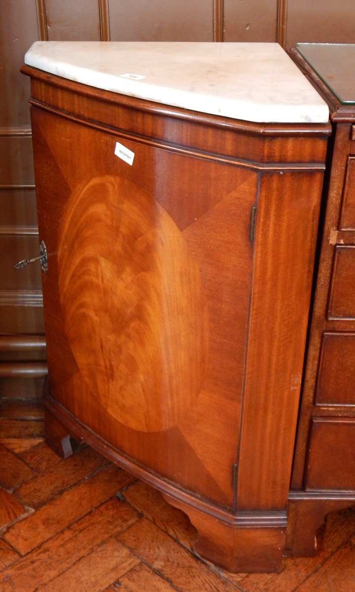 A mahogany bowfront corner cupboard with marbled top, raised on bracket feet,