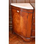 A mahogany bowfront corner cupboard with marbled top, raised on bracket feet,