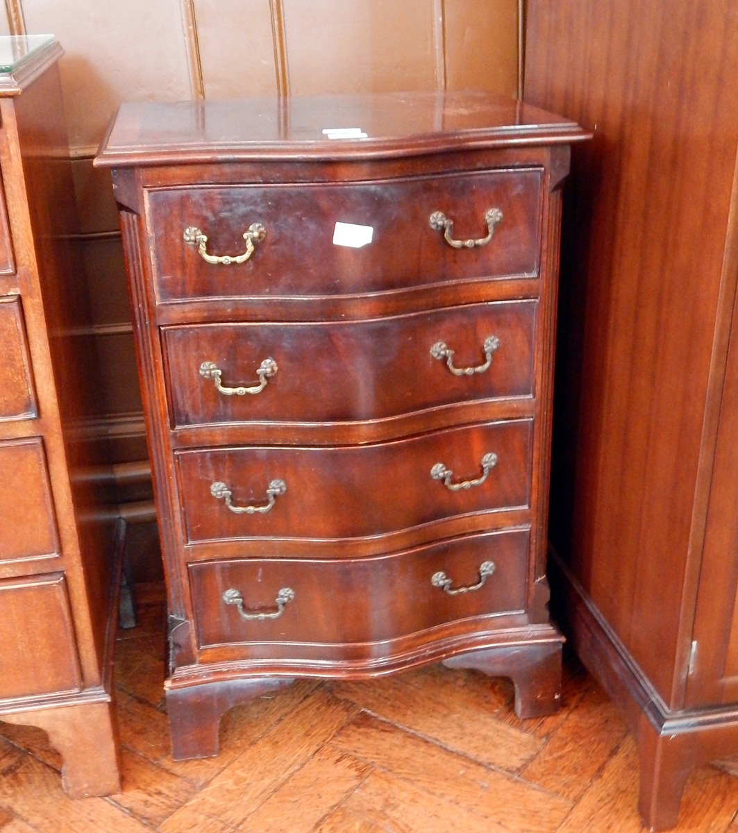 A reproduction Georgian style mahogany serpentine front chest of four long drawers,