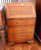 A mid 20th century oak bureau, the interior fitted with pigeonholes, three drawers below,