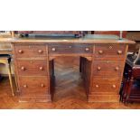 An oak pedestal desk with inset leather writing top, frieze drawer,