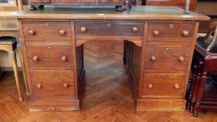 An oak pedestal desk with inset leather writing top, frieze drawer,