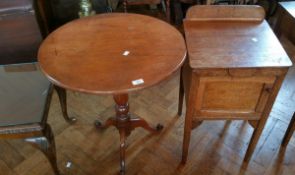 An oak circular tilt-top table together with a bedside cupboard,
