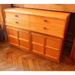 A contemporary teak chest of four short drawers with pair panelled cupboard doors below,