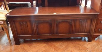 A reproduction oak coffer with linenfold panel front, on square legs,