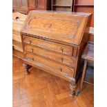 Twentieth century oak bureau with fitted interior, three long drawers on turned bulbous legs,