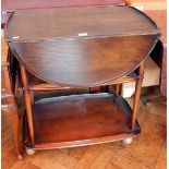 An Ercol style drop oval flap tea trolley, with two undershelves raised on castors,