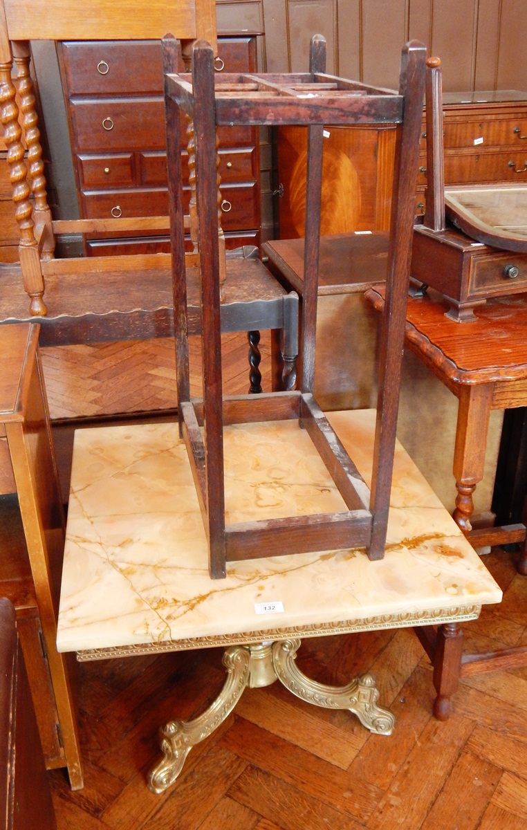 A marble square top coffee table on gold metal supports,