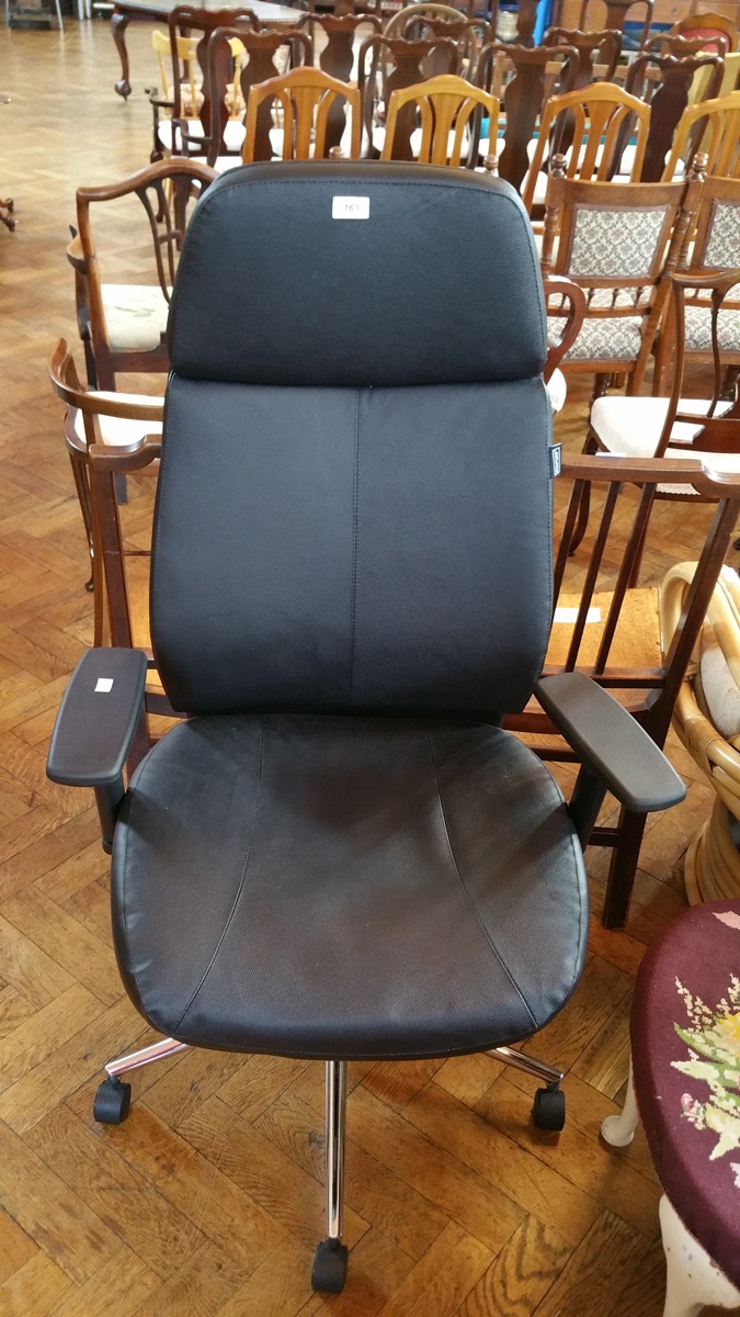 A black vinyl upholstered swivel computer chair on chrome stand and on castors