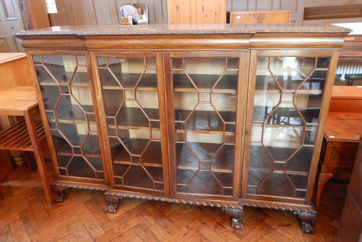 A mahogany Chippendale style breakfront bookcase, with carved foliate border, cushion frieze,