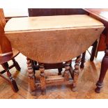 An old oak oval-top gateleg table on turned spiral supports united by stretchers,