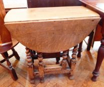 An old oak oval-top gateleg table on turned spiral supports united by stretchers,