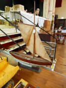 A wooden pond yacht "Speedwell" having rudder with raised masts and sails,