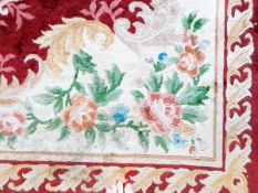 A large Chinese wool carpet with cream and red ground, floral decoration,