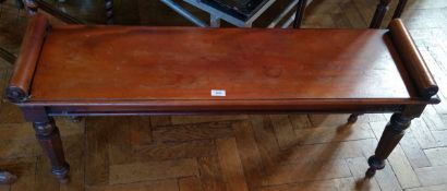 A Victorian mahogany window seat, with scroll ends on turned faceted tapering legs,