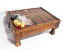 A backgammon board and pieces on raised legs, with two drawers,