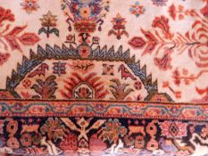 A Chinese wool rug with white ground and floral and geometric patterns, blue fencing,
