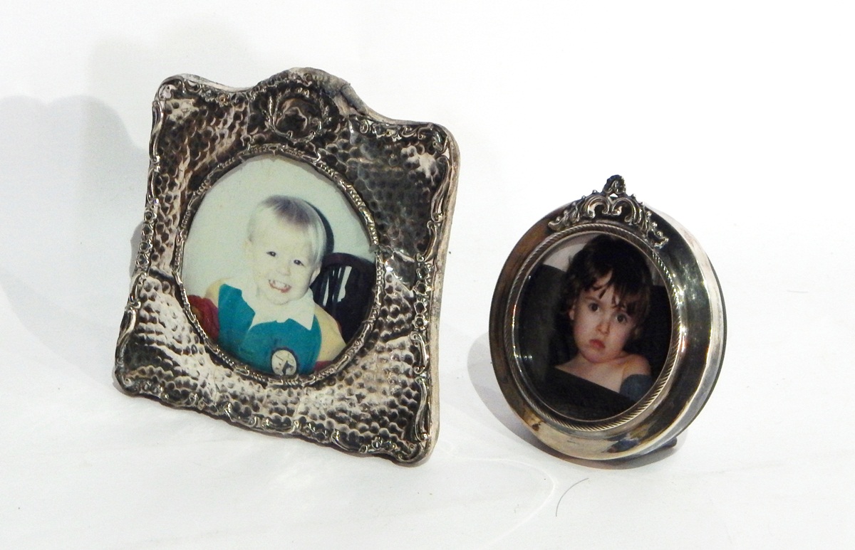 A silver photograph frame of hammered decoration and another circular example