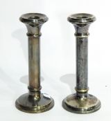 A pair of silver plated candlesticks of plain cylindrical form