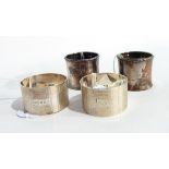 Two cased silver napkin rings of engine turned decoration and a pair of silver napkin rings with