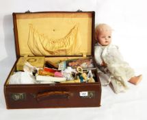 A suitcase and contents comprising a composition doll and various sewing items,