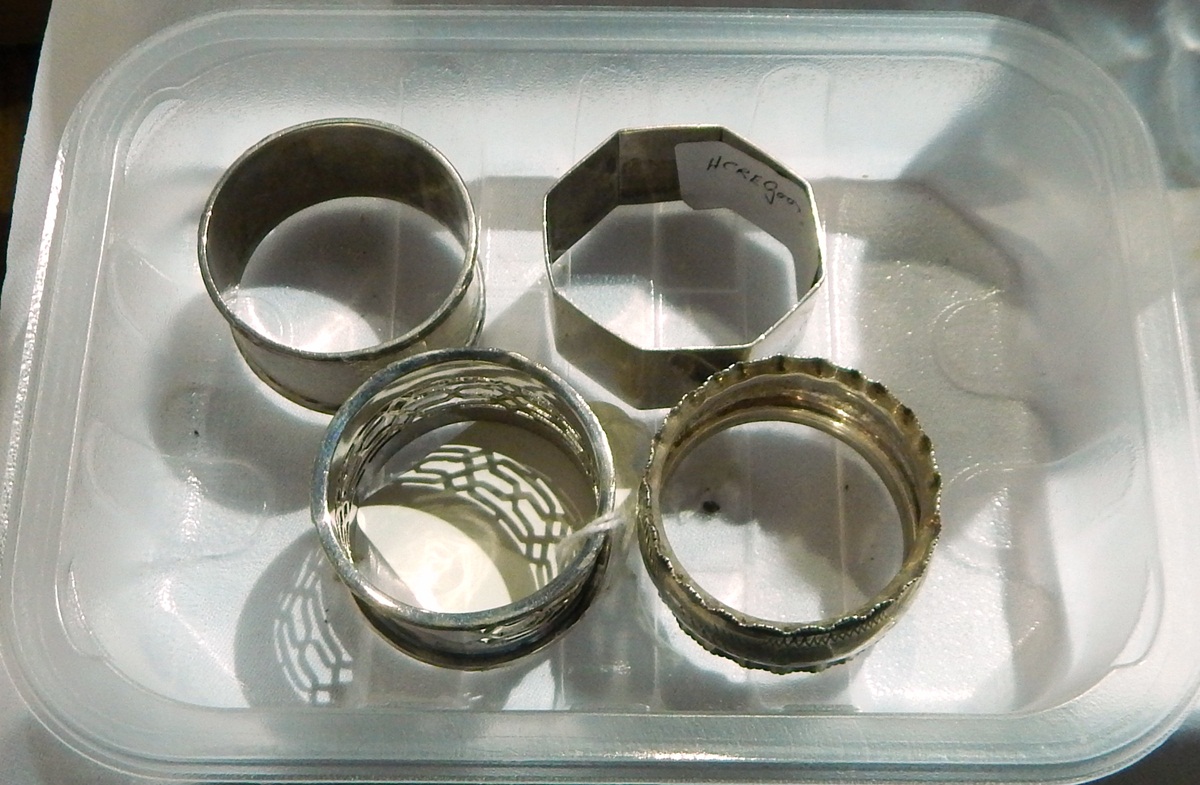 Three silver napkin rings and one other
