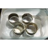 Three silver napkin rings and one other