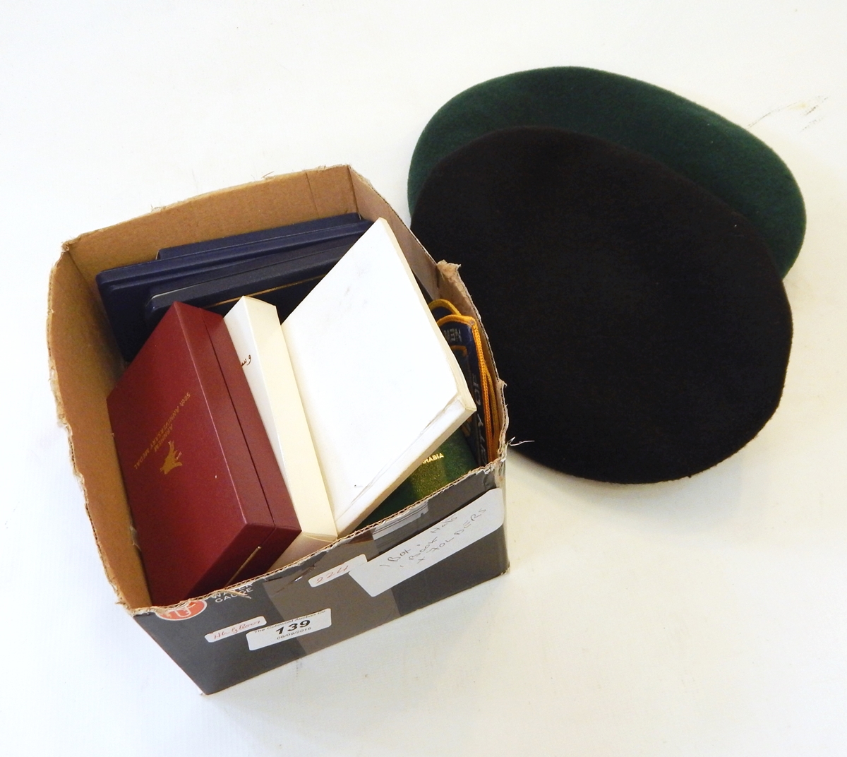 A quantity of badges and medals together with two berets and other items