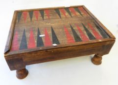 A painted wood backgammon board and pieces on raised legs, with two drawers,