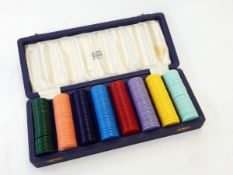 A cased set of Finnigans plastic gambling chips in eight different colours