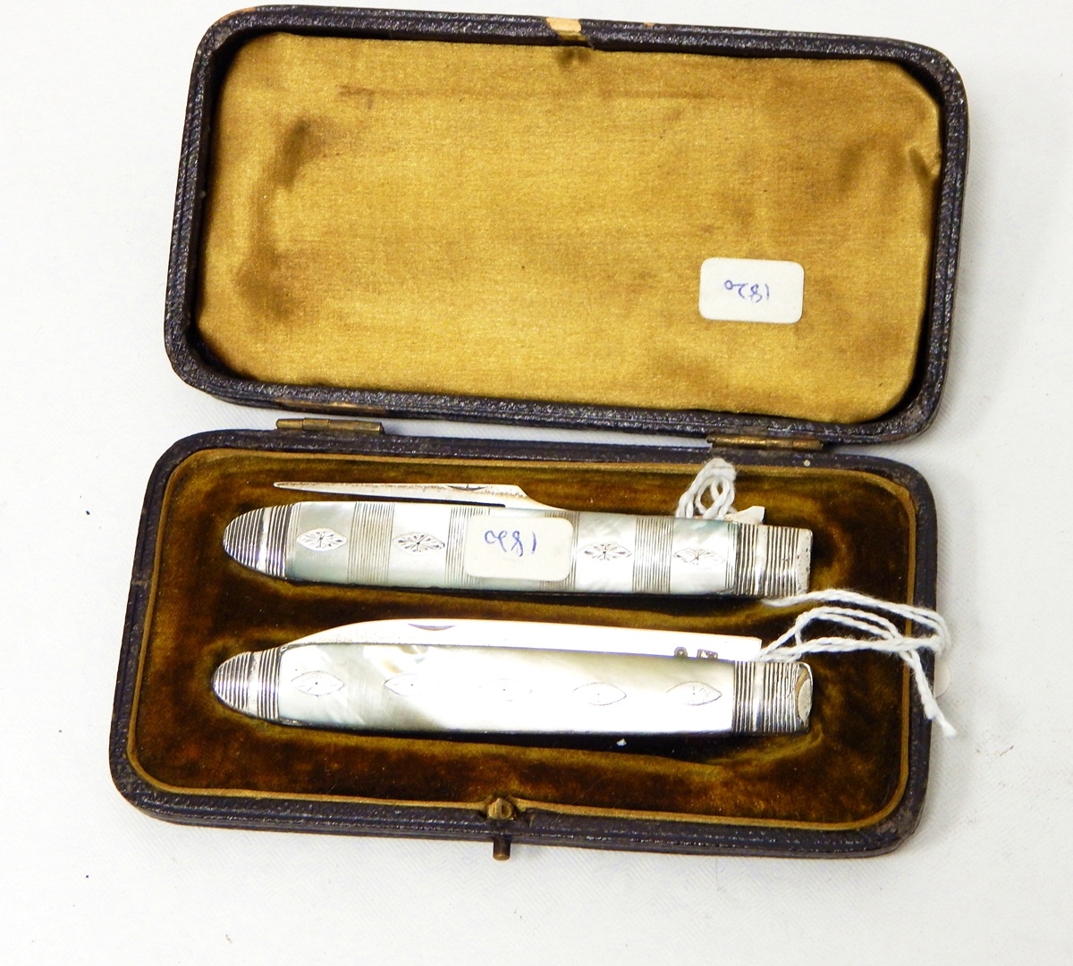 A Georgian silver knife and folding fork set with mother-of-pearl handles, insert metal decorations,