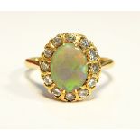 A gold, opal and diamond cluster ring, the central oval opal surrounded by 12 eight-cut diamonds,