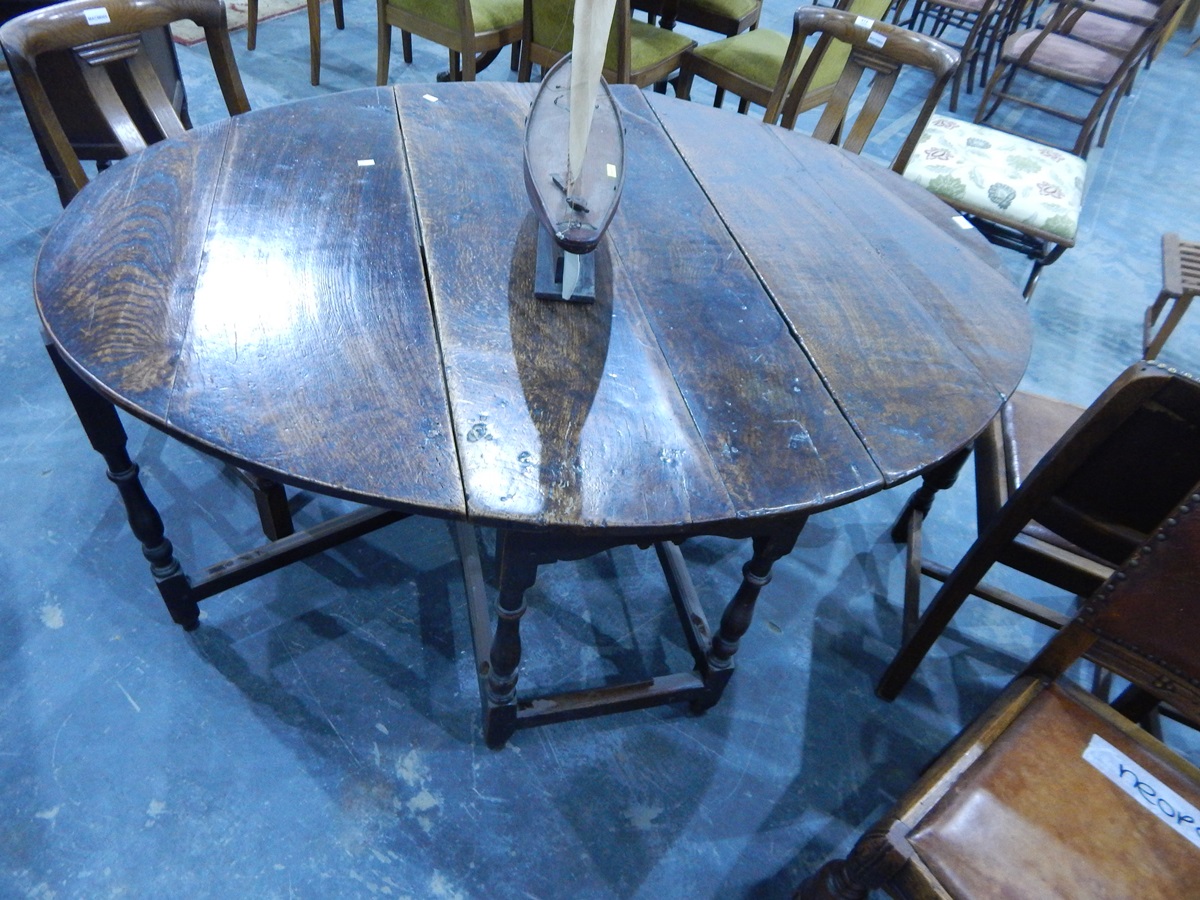 An antique oval oak fall-flap gateleg table on turned supports