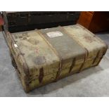 A wood-bound canvas cabin trunk bearing luggage labels