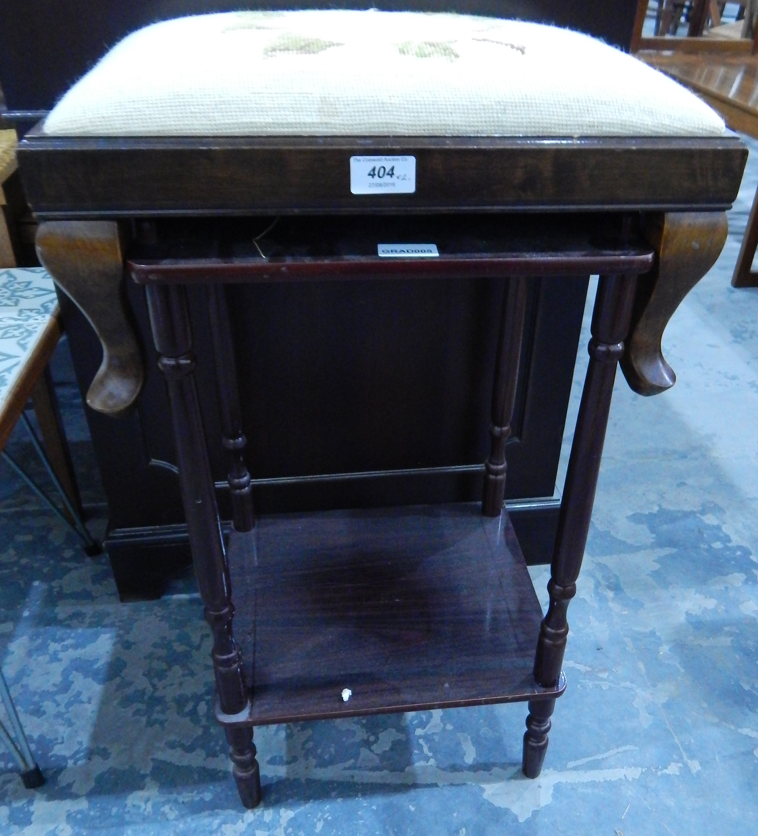 A woolwork embroidered footstool on squat cabriole legs and a two-tier telephone table with