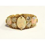 An 18ct gold, opal and diamond dress ring set three oval opals and four diamonds,