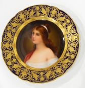 A Vienna porcelain plate, the centre painted with a maiden within a gilt and blue ground border,