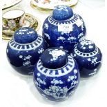 Four blue and white ginger jars and covers of varying sizes, decorated with prunus blossom,