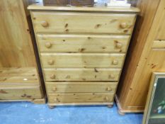 A modern pine pedestal chest of six drawers, each with turned knob handles and with turned bun feet,