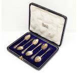 A set of six silver coffee spoons with engraved decoration, in fitted case and a silver thimble.