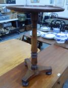 A Victorian oak pedestal table raised on turned column triform base and bun feet,