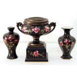 A Victorian two-handled pottery rose bowl decorated with pink roses on a black ground,