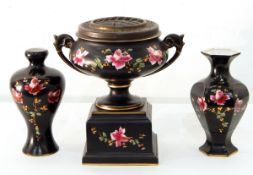 A Victorian two-handled pottery rose bowl decorated with pink roses on a black ground,