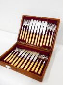 A mahogany cased set of 24 fish knives and forks with engraved decoration,