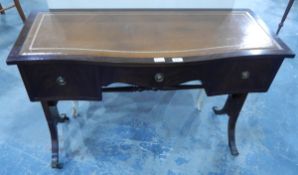 A reproduction mahogany serpentine-fronted writing table, the top with tooled leather inset,