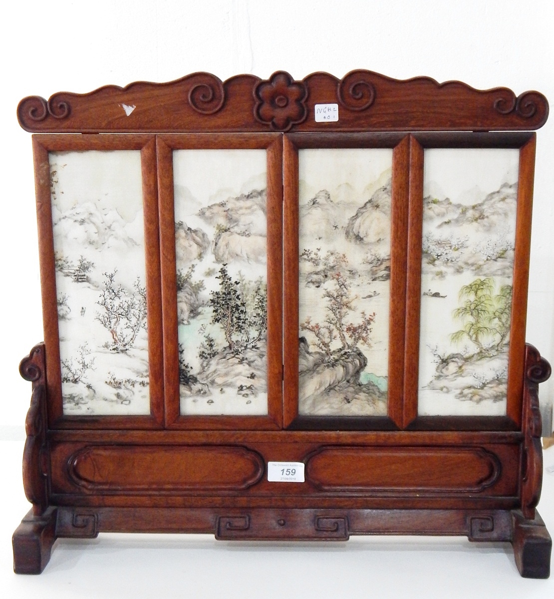 A Chinese table screen, the carved hardwood frame set with four painted porcelain panels,