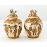 A pair of Japanese Satsuma ware jars and covers, each finely painted with figures,