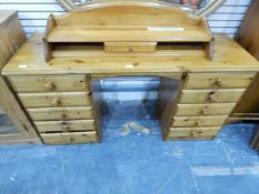 A modern pine kneehole dressing table with superstructure, fitted ten drawers,