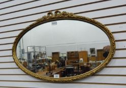 An oval moulded gilded framed wall mirror